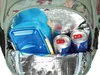 Close-up view of the interior of a backpack, showing a blue lunchbox and two cans of Red Bull. Produktbild-Vorschau