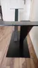 A black metal table base with a flat rectangular base and a central vertical support with a V-shaped element attached. Produktbild-Vorschau