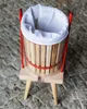 A top-down view of a fruit press with a white filter bag inside, resting on a stone surface. Produktbild-Vorschau