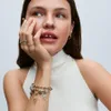A woman's hand with jewelry is shown, with a close-up on her rings and bracelet. Podgląd zdjęcia produktu