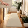 A hallway with a long beige runner rug, plants, and artwork. Produktbild-Vorschau