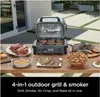 An outdoor grill with various cooked foods displayed on a wooden table. Voir les images du produit