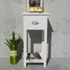 A white bedside table with a drawer and a shelf, placed against a textured gray wall. Podgląd zdjęcia produktu