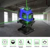 A blue laser level with green beams is shown on a black scissor lift stand in an unfinished building. Podgląd zdjęcia produktu