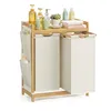 A bamboo laundry basket with two compartments and a top shelf holding toiletries and towels, set against a white background. Náhled obrázku produktu