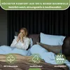 A woman is holding a mug while sitting in bed with light blue bedding. Produktbild-Vorschau
