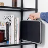 A hand holding a portable black and gray step stool on a shelf with books. Produktbild-Vorschau