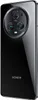 A black Honor Magic5 Pro smartphone is shown from the back, with its camera module prominently displayed. Podgląd zdjęcia produktu