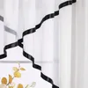 A close-up view of white sheer curtains with a black satin ribbon trim. Produktbild-Vorschau