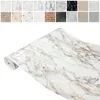 A roll of marble-patterned adhesive film is shown diagonally against a white background. Above the roll, there is a collage of smaller images showcasing various patterns and textures, likely representing other available designs of the same product. Produktbild-Vorschau