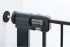 Close-up of a black metal safety gate mechanism mounted to a white wall. Voir les images du produit
