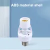 A white motion sensor lamp holder adapter is shown against a light blue and white striped background. Podgląd zdjęcia produktu