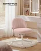 A pink fleece chair is placed on a fluffy rug in front of a white vanity table with a lighted mirror. Produktbild-Vorschau