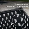 Close-up of a black metal fire pit with a diamond pattern of cutouts, showing a magnified section of the pattern. The background is a paved outdoor area. Náhled obrázku produktu