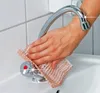 A hand is cleaning a sink faucet with a cloth. Anteprima dell’immagine prodotto