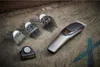 A hair clipper and its accessories are laid out on a textured surface. Podgląd zdjęcia produktu