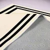 A close-up view of a beige rug with black stripes, showing the texture of the underside. Podgląd zdjęcia produktu