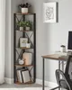 A corner shelf unit with books and plants next to a desk. Náhled obrázku produktu