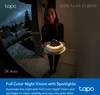 A woman is holding a cake in front of a house at night. Produktbild-Vorschau