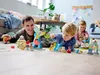 A father and two young children are playing with a LEGO DUPLO amusement park set on a wooden floor in a living room. Podgląd zdjęcia produktu