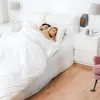 A couple sleeping in a bed with a small heater plugged into the wall nearby. Anteprima dell’immagine prodotto