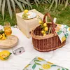 A picnic setup on a white blanket outdoors, with a picnic basket, wine glasses, cheese, grapes, and a camera. Náhľad obrázku produktu