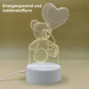 A 3D wireframe teddy bear lamp with a heart-shaped balloon, sitting on a white base with a USB cable attached. Produktbild-Vorschau