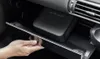 A hand is opening a car's glove compartment to reveal a black air compressor inside. Produktbild-Vorschau