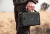 A person holding a portable power bank outdoors. Produktbild-Vorschau