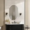 A modern bathroom vanity with a mirror, sink, faucet, and wall sconces. Voir les images du produit