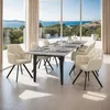 A dining room with a table and chairs set up, overlooking a scenic ocean view. Produktbild-Vorschau