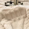 A close-up view of a thick, soft, beige blanket with a textured surface. Anteprima dell’immagine prodotto