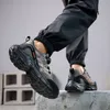 A person wearing safety shoes is stepping on a concrete block. Produktbild-Vorschau