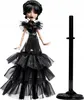 A doll wearing a black dress and standing next to a doll stand. Náhľad obrázku produktu
