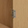 A close-up view of a metal hinge attached to a wooden cabinet or furniture. Podgląd zdjęcia produktu