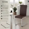 A dining chair is shown next to a table in a well-lit room with a window in the background. Náhled obrázku produktu