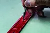 A hand is using a Pica Fine-Dry Marker Druckbleistift to mark a point on a red tool. Anteprima dell’immagine prodotto