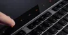 A close-up of a finger touching a touch-sensitive multimedia control panel on a keyboard. Produktbild-Vorschau