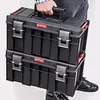 A person is carrying two stacked toolboxes. Náhled obrázku produktu