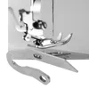 Close-up view of sewing machine parts, specifically the needle, presser foot, and two overlock knife blades. Produktbild-Vorschau