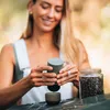 A woman is making coffee with a portable espresso maker. Produktbild-Vorschau