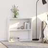 A white bookshelf with books and decorative items on it, placed on a rug next to a floor lamp and a sofa. Podgląd zdjęcia produktu