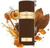 A perfume bottle surrounded by ingredients like tobacco leaves, honey, and fruit. Voir les images du produit