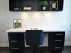 A modern home office desk with a chair and shelving above. Produktbild-Vorschau