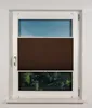 A window with a brown pleated blind partially covering the view of trees and a river. Produktbild-Vorschau
