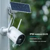 A white security camera with a solar panel attached, mounted on a pole in the rain. Náhled obrázku produktu