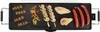 A top-down view of a black electric teppanyaki grill with various foods cooking on it. Produktbild-Vorschau