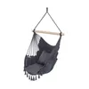 A hanging chair with a pillow and tassels, suspended from a wooden bar. Produktbild-Vorschau