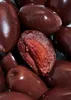 A close-up view of several dark red olives, with one olive cut in half to reveal its pit and flesh. Produktbild-Vorschau