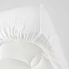 A close-up of a white fitted sheet on a mattress. Anteprima dell’immagine prodotto